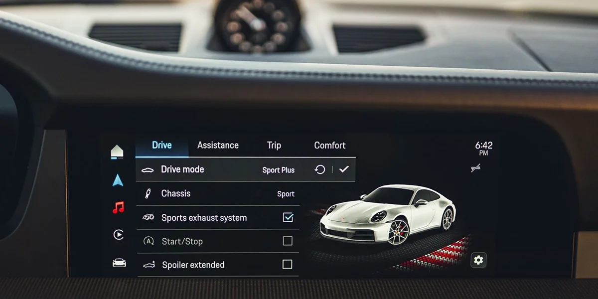 2026 Porsche 911 Carrera S digital infotainment display with Sport Plus drive mode, sports exhaust system, and performance settings highlighted.