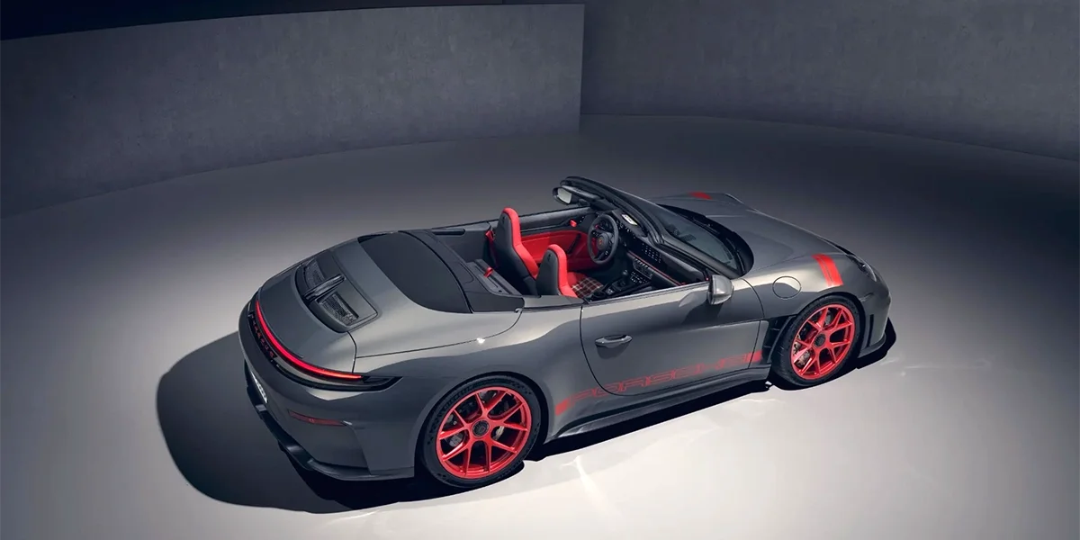 Rear three-quarter view of grey Porsche 911 GT3 RS Cabriolet with red accents and red wheels.